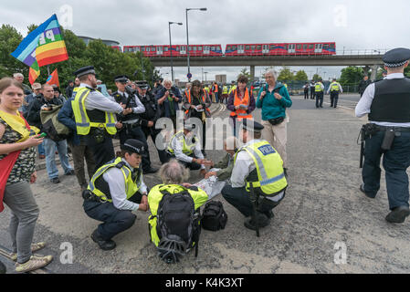 September 5, 2017 - London, UK - London, UK. 5. September 2017. Polizei sprechen Sie mit Quaker Demonstranten auf die Straße Am zweiten Tag der Proteste gegen die größten Waffen der Welt in den Londoner Docklands abgehalten. Die "Kein Vertrauen in Krieg" Tag war eine Reihe von Veranstaltungen, die von verschiedenen Glauben Gruppen organisiert. Bevor ich ankam hatte es einen Lock-in auf der Zufahrtsstraße stoppen Lieferungen auf der Messe über das Tor zu setzen. Dies wurde gefolgt von einem Quaker Meeting an der Seite der Straße, bei dem eine Reihe von Personen stand oder lag die Straße zu blockieren und mehrere, die sich weigerten, sich zu bewegen, wurden festgenommen. Stockfoto