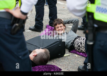 London, Großbritannien. 6. September 2017. Aktivisten gegen den Waffenhandel liegen in der Fahrbahn miteinander verbunden mit "Lock-on"-Röhren die Zufahrtsstraße zum ExCel Centre zu blockieren, militärische Ausrüstung von Lkw ankommen für die dsei Arme, die nächste Woche zu verhindern. Stockfoto