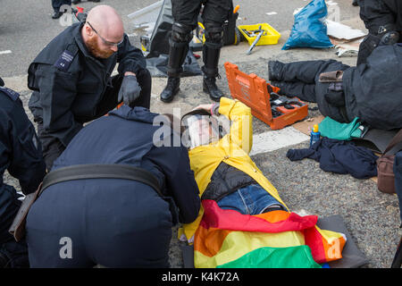 London, Großbritannien. 6. Sep 2017. Anti-Trident Aktivisten von Trident Ploughshares liegen in der Fahrbahn miteinander verbunden mit "Lock-on"-Röhren die Zufahrtsstraße zum ExCel Centre zu blockieren, militärische Ausrüstung von Lkw ankommen für die dsei Arme, die nächste Woche zu verhindern. Credit: Mark Kerrison/Alamy leben Nachrichten Stockfoto