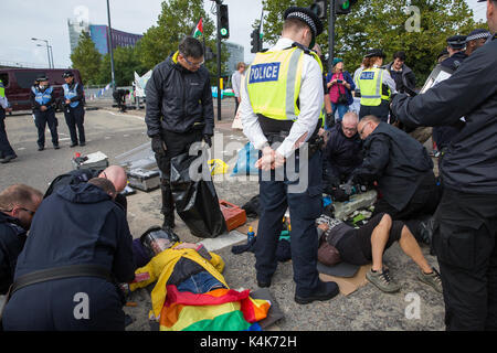 London, Großbritannien. 6. Sep 2017. Anti-Trident Aktivisten von Trident Ploughshares liegen in der Fahrbahn miteinander verbunden mit "Lock-on"-Röhren die Zufahrtsstraße zum ExCel Centre zu blockieren, militärische Ausrüstung von Lkw ankommen für die dsei Arme, die nächste Woche zu verhindern. Credit: Mark Kerrison/Alamy leben Nachrichten Stockfoto