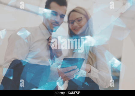 Junge erfolgreiche Geschäftsleute mit Tablet-PC im Büro, blau leuchtende Polygone, Schärfentiefe Stockfoto
