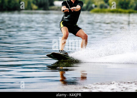 Extreme Sport Mann reitet ein Wakeboard auf See Stockfoto
