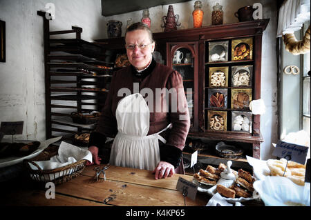 Eine Frau in Kostümen verkauft dänischen Gebäck in einem Shop in Den Gamle By, ein open air Folk Museum in Aarhus, Dänemark bekannt. Stockfoto