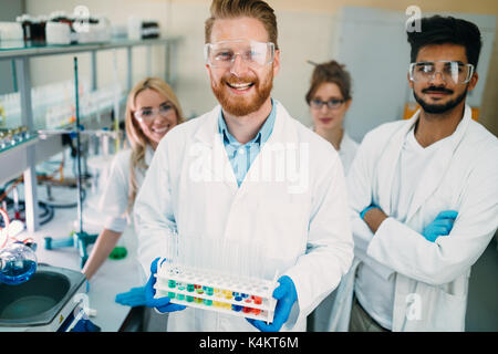 Gruppe junge erfolgreiche Wissenschaftler für die Kamera posieren Stockfoto