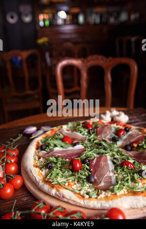 Leckere Pizza mit Schinken und Paprika im Restaurant Stockfoto