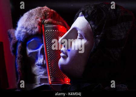 Eine bunte noch das Leben eines künstlichen Schädel und ein weibliches Gesicht Statue. Blau und Rot studio Leuchten und künstlerische Komposition Stockfoto