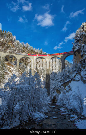 Bernina Express führt durch die verschneiten Wälder rund um Filisur Kanton Graubünden-Schweiz-Europa Stockfoto