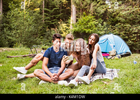 Jugendliche vor Zelten im Wald. Stockfoto