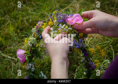 Zusammen weben Wildblumen eine Tiara zu erstellen. Stockfoto