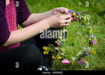 Zusammen weben Wildblumen eine Tiara zu erstellen. Stockfoto