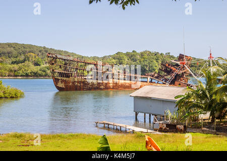 Teilweise eingetaucht rostigen Schiffswrack Skelett vor der Küste von malerischen Roatan, Bay Islands, Honduras, Karibik an einem sonnigen Tag, blauer Himmel Stockfoto