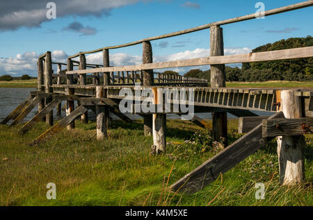 Ein Holzsteg über Wattenmeer bei Flut an Aberlady Bay Local Nature Reserve, East Lothian, Schottland, Großbritannien Stockfoto