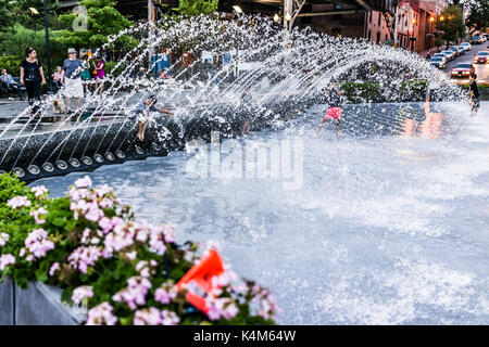 Washington DC, USA - August 4, 2017: Junge Kinder spielen im Wasser Brunnen in Georgetown Park in den Abend mit Wasser spritzen Stockfoto