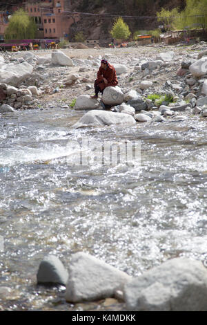 Berber Mann entspannt durch Fluß während der Souk von setti Fatma, Ourika Valley, Atlas, Marokko Stockfoto