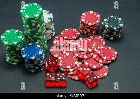 Poker chips auf schwarzem Hintergrund und 5 rote Würfel stapeln Stockfoto