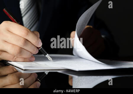 Notar die Unterzeichnung eines Vertrags mit Füllfederhalter in dunklen Zimmer Konzept. Pen business Mann recht Rechtsanwalt Rechtsanwalt Notar Stockfoto