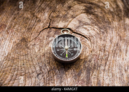 Ein kleiner tragbarer Trocken magnetischen Kompass auf eine körnige Holz- Hintergrund Stockfoto