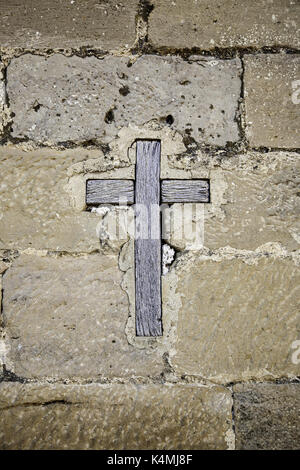 Mittelalterliche Holzkreuz auf einer Steinmauer, Detail der christlichen Objekt Stockfoto