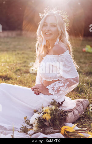 Bezaubernde Braut mit Tiara auf Natur Hintergrund. Moderne Braut Stil. Boho Fashion Hochzeit. Gefilterte Kreuz verarbeitet Foto mit Bokeh und Kopieren. Stockfoto