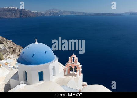 Klassische Ansicht über die Caldera, blau Kuppelkirche und rosa Glockenturm, Oia, Santorini, griechische Inseln, Griechenland, Europa Stockfoto