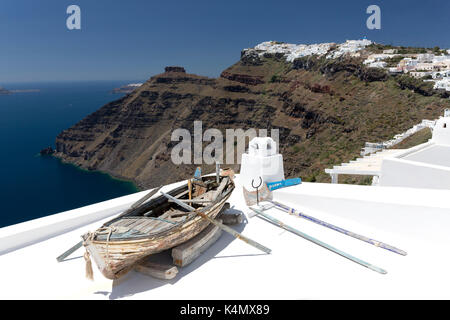 Blick in Richtung von Imerovigli Firostefani mit alten Ruderboot am Dach des Hotels, Santorini, Kykladen, griechische Inseln, Griechenland, Europa Stockfoto