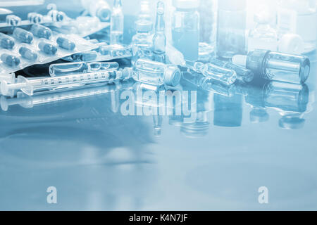 Glas Arzneimittelfläschchen Ampulle, Medizin Pille und Kapsel Spritze auf x-ray Film über Arzt Tabelle für Hintergrund mit Kopie Raum auf vorderer Bereich Stockfoto