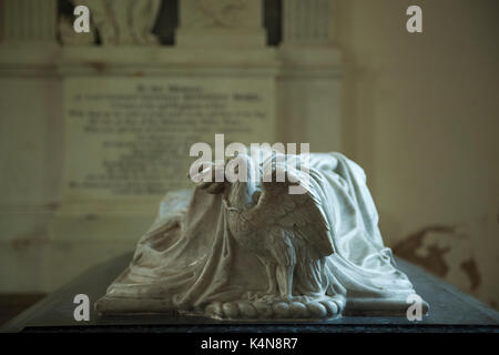 Kunstvoll geschnitzten Adler mit einer Schlange, die Teil eines schwarzen und weißen Marmor Grab in der Kirche von St. Peter und St. Paul, Exton, Rutland, England. Stockfoto