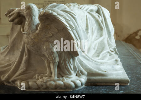 Kunstvoll geschnitzten Adler mit einer Schlange, die Teil eines schwarzen und weißen Marmor Grab in der Kirche von St. Peter und St. Paul, Exton, Rutland, England. Stockfoto