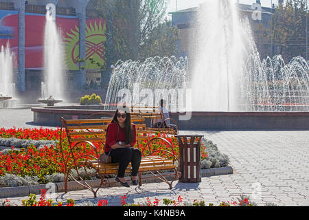 Brunnen und Kirgisischen Frau sitzt im ala-too Square in Bischkek, Hauptstadt von Kirgisistan Stockfoto