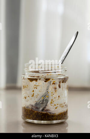 Ein fast leerer Krug vollkorn Senf und Teelöffel heraus haften. Anstatt zu Abfall, was ist links können in eine Salatsoße gedreht werden. Stockfoto