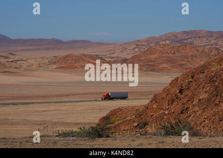 Lastwagen auf der Pan American Highway (Route 5), die durch die raue und karge Landschaft der Atacama im Norden Chiles. Stockfoto