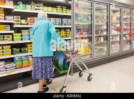 Ältere Frau einkaufen in Asda Supermarkt. Großbritannien Stockfoto