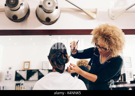 Professionelle friseur Styling der Haare von einem Kunden im Salon. Weibliche Friseur Haar Einstellung in modischem Design. Stockfoto