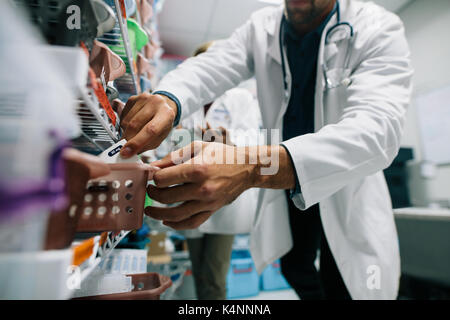 Arzt hand Finden einer Medizin im Krankenhaus Apotheke. Medizinisches Personal auf der Suche nach Medikamenten in der Apotheke. Stockfoto