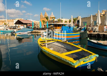 MARSAXLOKK, MALTA - 23. AUGUST 2017: Traditionelle bunte Luzzu Fischerboote ankommen und Verankerung in den frühen Morgen im Hafen von Marsaxlokk Stockfoto