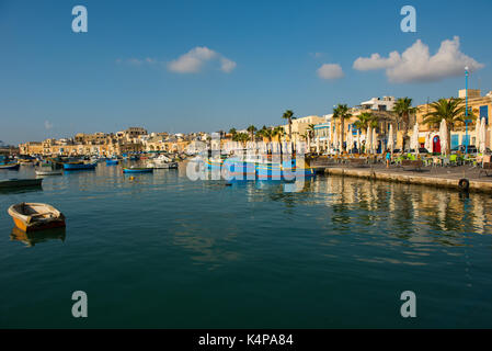 MARSAXLOKK, MALTA - 23. AUGUST 2017: Traditionelle bunte Luzzu Fischerboote ankommen und Verankerung in den frühen Morgen im Hafen von Marsaxlokk Stockfoto