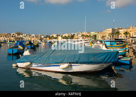 MARSAXLOKK, MALTA - 23. AUGUST 2017: Traditionelle bunte Luzzu Fischerboote ankommen und Verankerung in den frühen Morgen im Hafen von Marsaxlokk Stockfoto