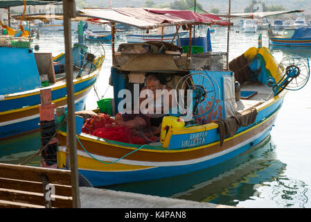 MARSAXLOKK, MALTA - 23. AUGUST 2017: Traditionelle bunte Luzzu Fischerboote ankommen und Verankerung in den frühen Morgen im Hafen von Marsaxlokk Stockfoto