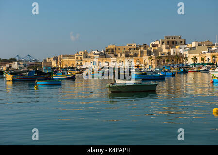 MARSAXLOKK, MALTA - 23. AUGUST 2017: Traditionelle bunte Luzzu Fischerboote ankommen und Verankerung in den frühen Morgen im Hafen von Marsaxlokk Stockfoto