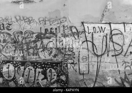 Alte vandalized Wand voller Graffiti, Tags, Schriften und Sprühfarbe in Prag, Tschechische Republik, in Schwarz und Weiß. Stockfoto