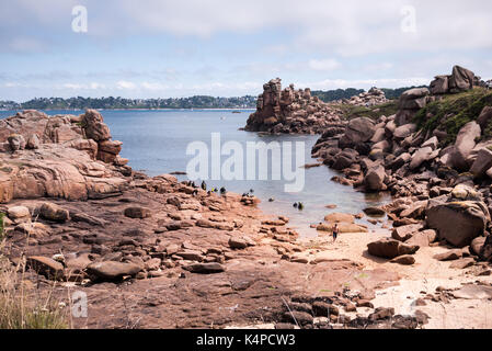 Ruhigen Einlass mit Felsformationen und eine Gruppe von Tauchern, die sich aus dem Meer Cote De Granit Rose Bretagne Frankreich Stockfoto