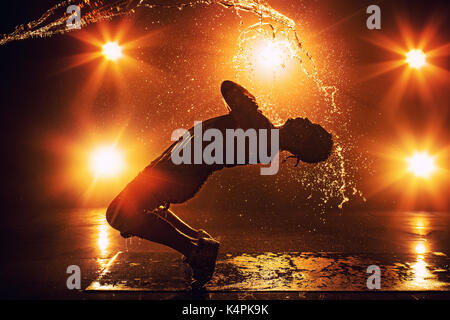 Junger Mann Breakdancer mit Licht- und Wassereffekte. Tattoo auf der Hand. Stockfoto