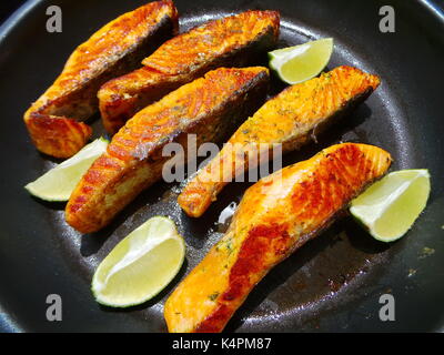 Nahaufnahme von saftigen Lachsfilets Braten mit Zitronenscheiben Stockfoto