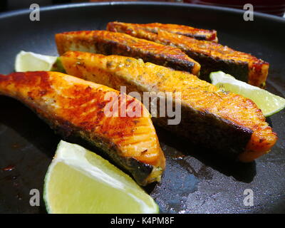 Nahaufnahme von saftigen Lachsfilets Braten mit Zitronenscheiben Stockfoto