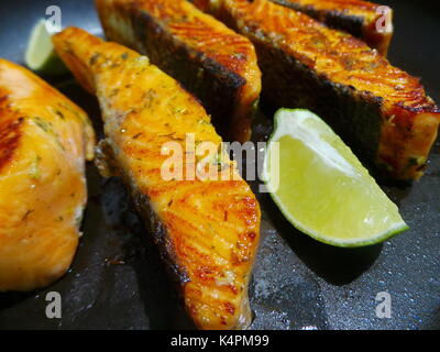 Nahaufnahme von saftigen Lachsfilets Braten mit Zitronenscheiben Stockfoto