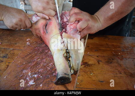 Rohe Schweinekopf gesägt in der Hälfte auf einer hölzernen Schneidebrett Stockfoto