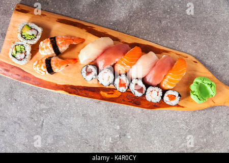 Verschiedene Arten von Sushi serviert auf einem Tablett mit Sojasauce, Wasabi und eingelegtem Ingwer. Stockfoto