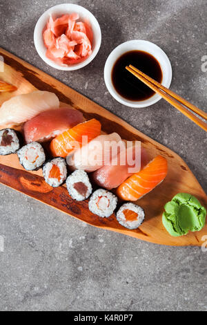 Sushi Set gunkan, Nigiri und Brötchen am grauen Stein Tisch serviert Stockfoto