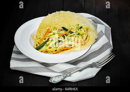 Teller Spaghetti mit gefülltes Gemüse serviert auf geschmolzenem Käse Waffel. Stockfoto