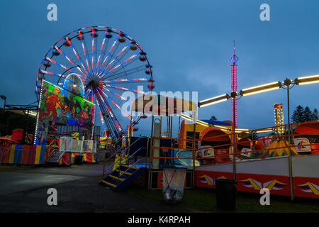 Schaghticoke Hoosic Valley County County Fair mit den Lichtern, Reflexionen, Fahrten, an einem regnerischen sonnige Nacht. Schaukeln, Riesenrad, Merry go round, und f Stockfoto